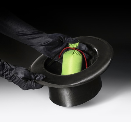 magic scenery with a black top hat and gloved hands in gradient dark backの写真素材