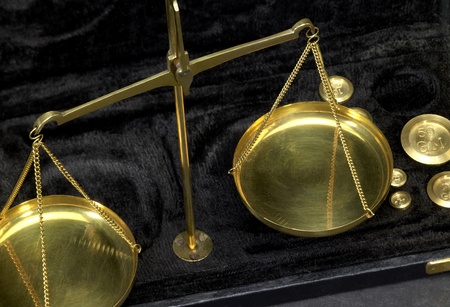 historic scales with metallic weights in dark backの写真素材