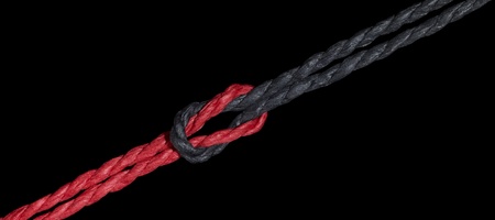 a red and a black string knotted togetherの写真素材