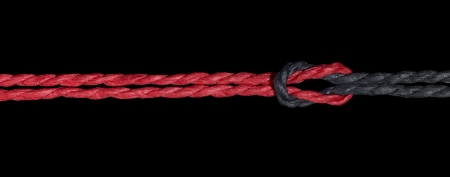 a red and a black string knotted togetherの写真素材