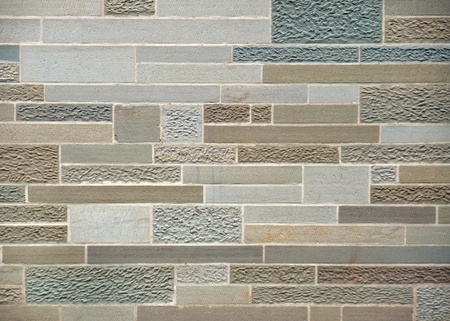 full frame detail of a stone wall with various processed stone surfaces