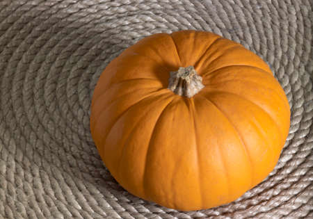 high angle shot of a orange pumkin on a rolled rope