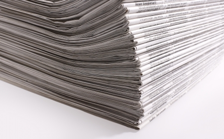 lots of stacked newspapers in light back