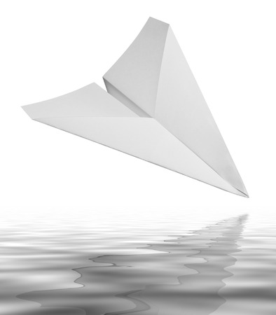 falling white paper plane on reflective water surface in white backの写真素材