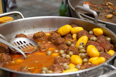 metallic pot including a oriental dish with meat balls, olives and potatoes in spicy sauceの写真素材