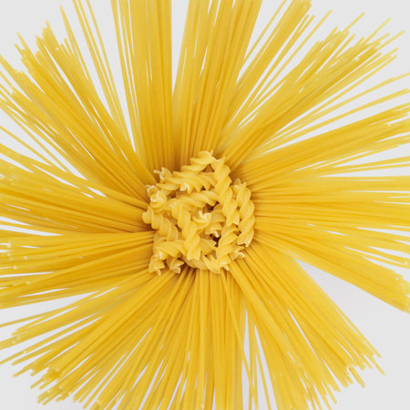 lots of radiant spaghetti and some rotini noodles in light grey backの写真素材