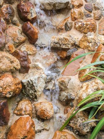 small water stream flowing over brown pebblesの写真素材