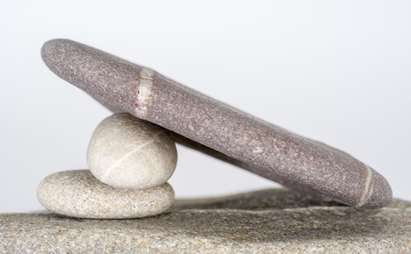 stacked rounded stone pebble arrangement in light grey backの写真素材