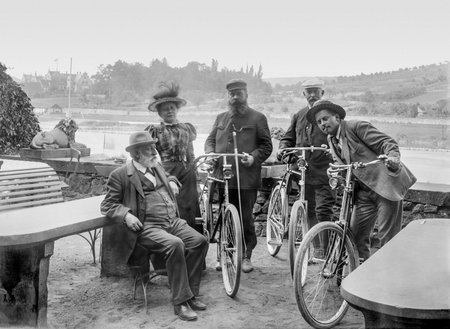 historic picture from a glass negative showing traditional dressed people resting with some bicyclesのeditorial素材