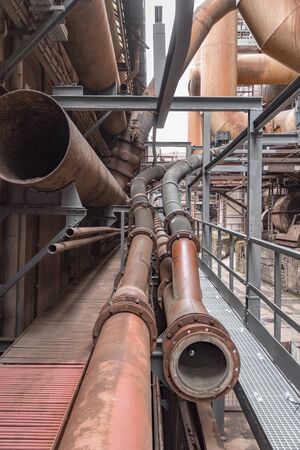 weathered rusty industrial scenery with old corroded steel girders and metal tubesの写真素材