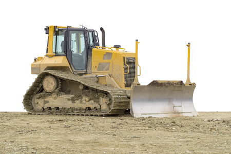 yellow bulldozer at a loamy construction site in white backの写真素材