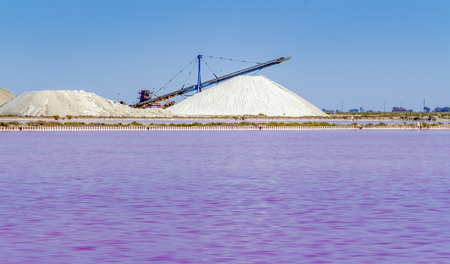Salt works scenery in the Camargue area in southern France with pink salt evaporation pond in sunny ambianceの写真素材