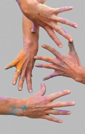 female hands covered with colorful paint splatters in light gray backの写真素材