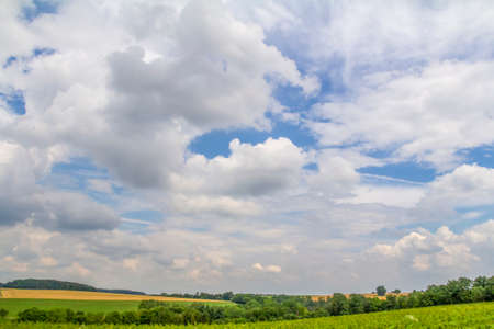 panoramic rural scenery under wide partly clouded sky at summer time in Southern Germanyの写真素材