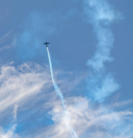 Aerobatics scenery showing a flying propeller-driven airplane with smoke trail