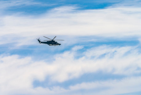 Helicopter flying in front of sky with some cloudsの写真素材