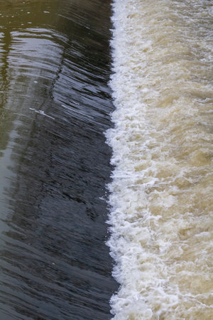 Detail shot showing flowing water at a weirの写真素材