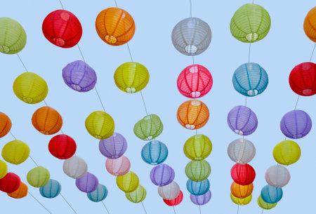 Low angle outdoor shot of colorful paper lanterns in front of blue skyの写真素材