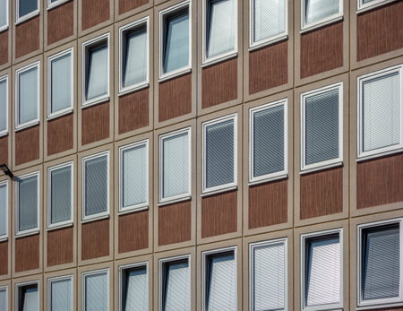 Full frame shot showing the facade of an office building including windows with closed shutters