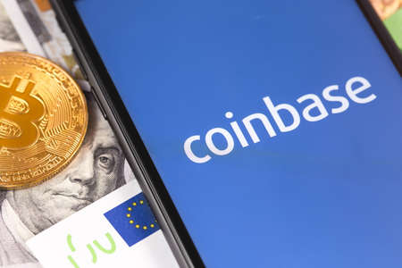 bitcoin, dollars, euro banknotes and smartphone with Coinbase logo on the screen. Coinbase is a digital currency exchange. Moscow, Russia - February 13, 2019のeditorial素材