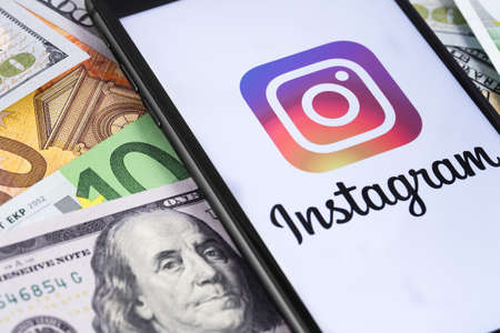 money and smartphone displaying the Instagram logo. Social media. Instagram is a photo-sharing app for smartphones. Moscow, Russia - March 12, 2019のeditorial素材