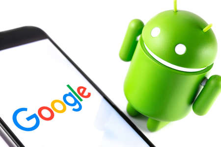 closeup Google Android figure and smartphone with Google logo. Google Android is the operating...