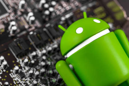 closeup Google Android figure and circuit board. Google Android is the operating system for smartphones, tablet computers, and other devices. Moscow, Russia - March 17, 2019のeditorial素材