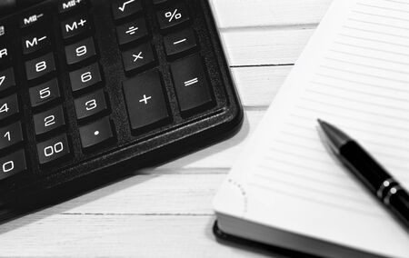 closeup workplace with calculator, notepad and pen on the wooden table deskの写真素材