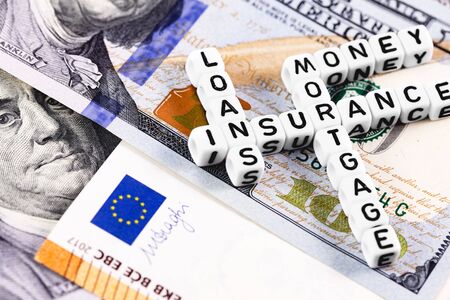 macro finance concept in blocks with words Insurance, Money, Loans and Mortgage on euros, dollars...