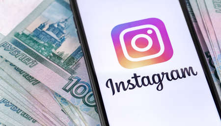 smartphone with Instagram logo on the screen and Russian money, rubles. Social media. Instagram is a photo-sharing app for smartphones. Moscow, Russia - June 25, 2019のeditorial素材