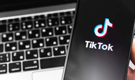 TikTok symbol on the screen smartphone and notebook background closeup. TikTok is app to create and share videos. Moscow, Russia - September 23, 2019のeditorial素材