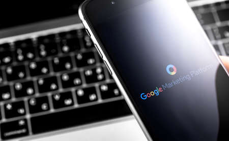 Google Marketing Platform logo on the display smartphone and notebook background closeup. Google Ads...