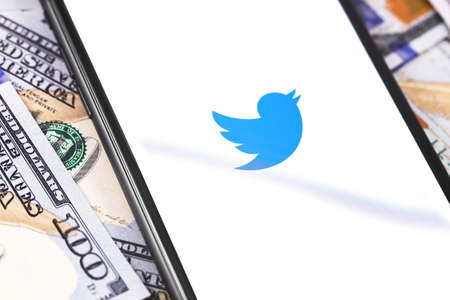 Twitter logo on the white screen smartphone and money. Twitter is a social media online service for...