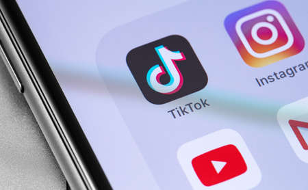 TikTok icon and popular mobile apps on the screen smartphone closeup. TikTok is app to create and share videos. Moscow, Russia - September 19, 2019のeditorial素材