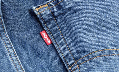 Levis red tag on denim, jeans texture. Levi Strauss is an american clothing company. Moscow, Russia - December 23, 2019のeditorial素材