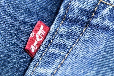 Levis red tag on denim jeans texture closeup. Levi Strauss is an american clothing company. Moscow,...