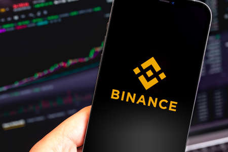 Binance logo mobile app on screen iPhone and MacBook closeup. Binance is one of the largest cryptocurrency exchange on the market. Moscow, Russia - January 12, 2021のeditorial素材
