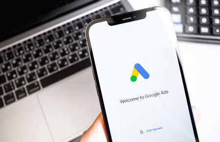 Google Ads (AdWords) logo on the screen iPhone, notebook background. Google is the biggest Internet...