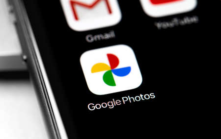 Google Photos app on the sceen smartphone. Google Photos icon application on the screen smartphone. Google Photos - a service designed to store, edit, share photos and videos. Moscow, Russia - August 15, 2020のeditorial素材