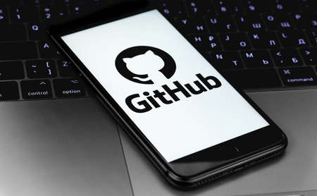GitHub logo on the screen smartphone with notebook keyboard. GitHub is the largest web service for hosting and developing IT projects. Moscow, Russia - July 12, 2020のeditorial素材