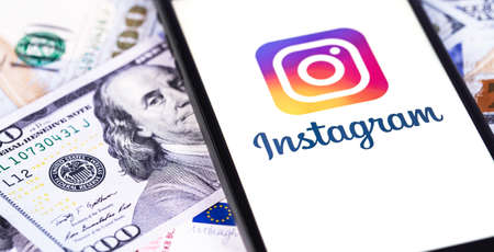 Instagram logo on the display smartphone closeup with money background. Instagram is a photo-sharing app for smartphones. Moscow, Russia - July 24, 2020のeditorial素材