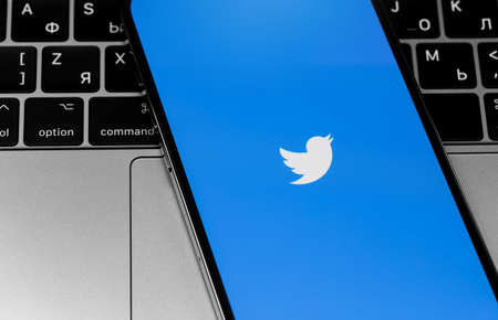 Twitter mobile app logo on the screen smartphone on laptop closeup. Twitter is a social media online service for microblogging and networking communication. Moscow, Russia - December 3, 2020のeditorial素材