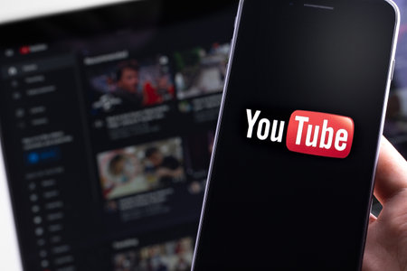 YouTube logo on the screen smartphone and homepage on the display laptop. YouTube is a free video sharing application that anyone can watch. Moscow, Russia - April 20, 2020のeditorial素材