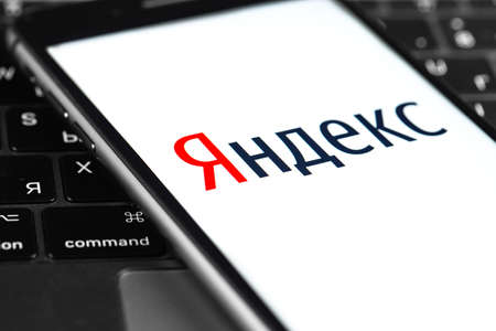 Yandex logo on the screen smartphone with notebook closeup. Yandex is a Russian multinational company. Moscow, Russia - March 20, 2020のeditorial素材