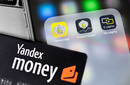 Yandex Money card and smartphone with Tinkoff Bank mobile apps. Tinkoff Bank is a Russian commercial bank. Moscow, Russia - September 25, 2020のeditorial素材