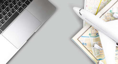 tourist travel concept, closeup MacBook and maps with airplane toy, holiday season vacation. Apple...