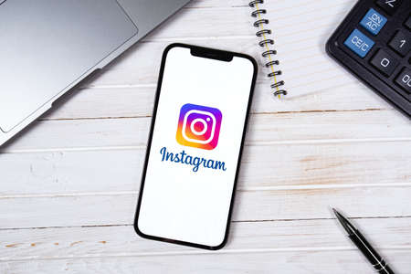 Instagram mobile app on screen smartphone iPhone on workplace. Instagram is a photo-sharing app for smartphones. Moscow, Russia - January 22, 2021のeditorial素材