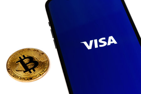 Visa logo app on screen smartphone and bitcoin cryptocurrency. Visa - American multinational company providing services of payment operations. Moscow, Russia - January 15, 2021のeditorial素材