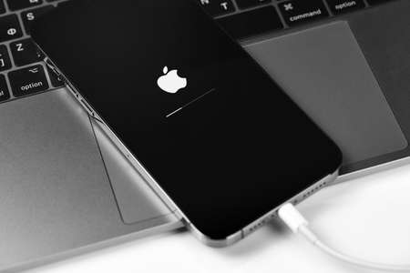 iPhone with iOS update, Apple icon and status bar on screen. Apple is a multinational technology company. Moscow, Russia - January 14, 2021のeditorial素材