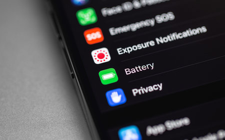 smartphone iPhone with Battery health-Settings interface on screen. Apple is a multinational...
